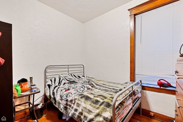 bedroom featuring wood finished floors and baseboards