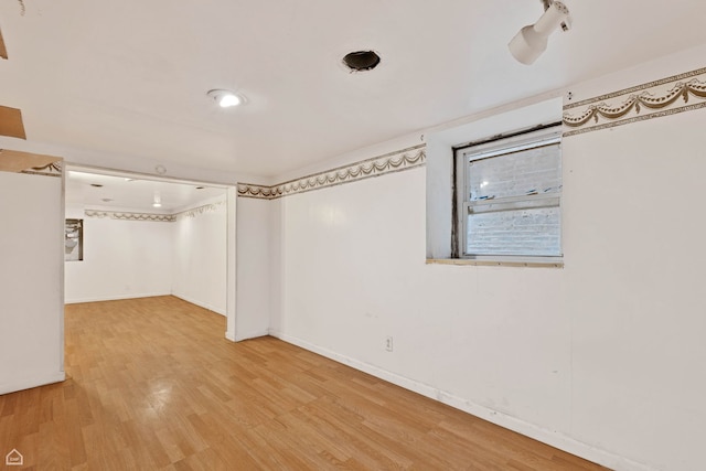 below grade area featuring baseboards and wood finished floors