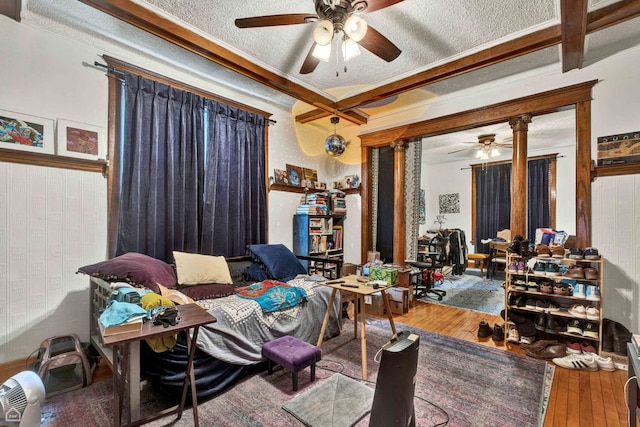 living room with crown molding, ceiling fan, hardwood / wood-style floors, and a textured ceiling