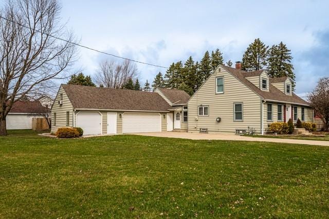 view of front of home featuring a front yard, a garage, driveway, and a chimney
