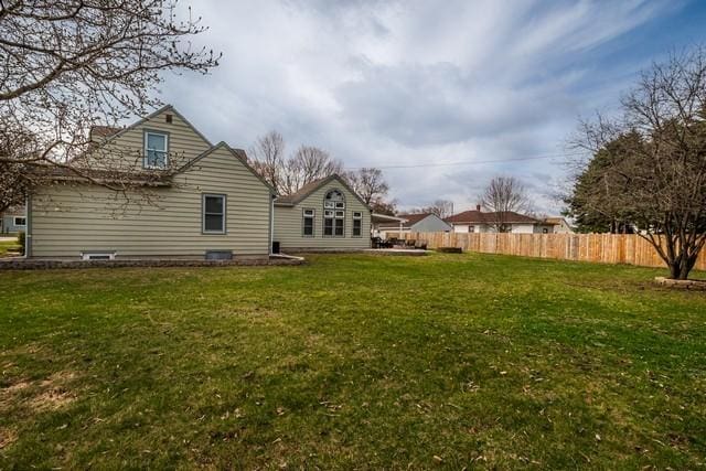 back of property featuring a yard and fence