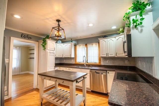 kitchen featuring tasteful backsplash, a sink, white cabinetry, stainless steel appliances, and pendant lighting