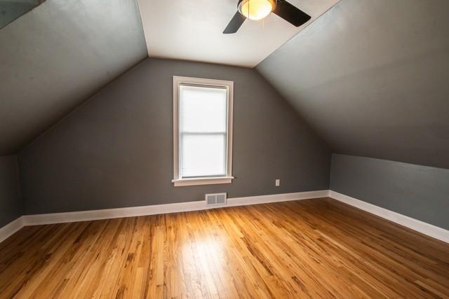 bonus room with wood finished floors, baseboards, and visible vents