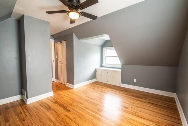 additional living space with ceiling fan, light wood finished floors, and baseboards