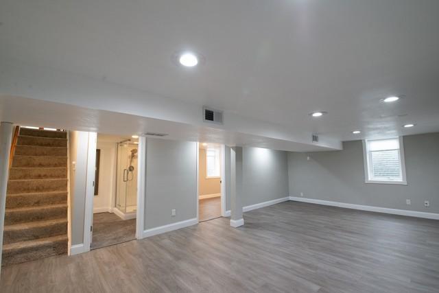 below grade area featuring baseboards, recessed lighting, stairs, visible vents, and wood finished floors