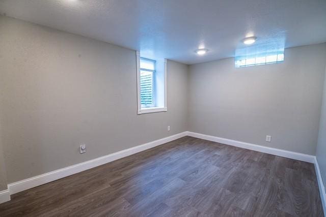 basement featuring baseboards and dark wood finished floors
