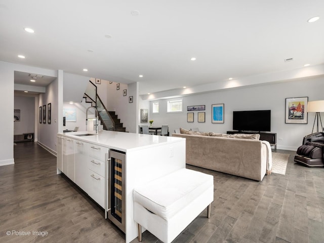 kitchen with wine cooler, a sink, white cabinetry, and recessed lighting