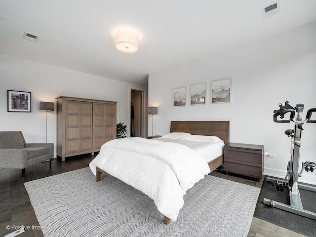 bedroom with visible vents, baseboards, and dark wood-style floors