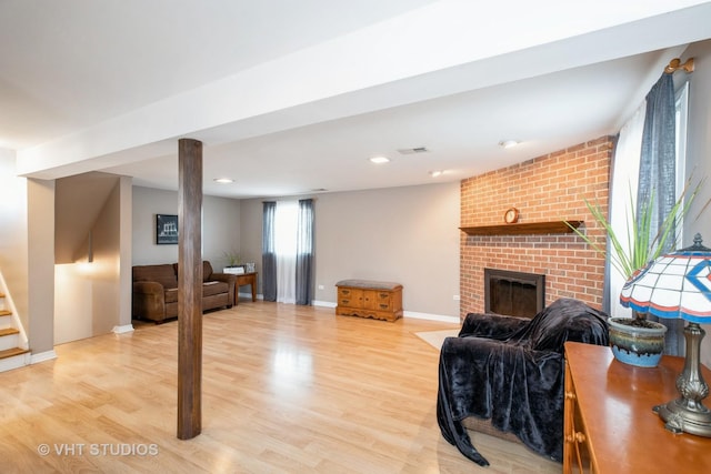 living room with baseboards, light wood-style floors, a fireplace, recessed lighting, and stairs