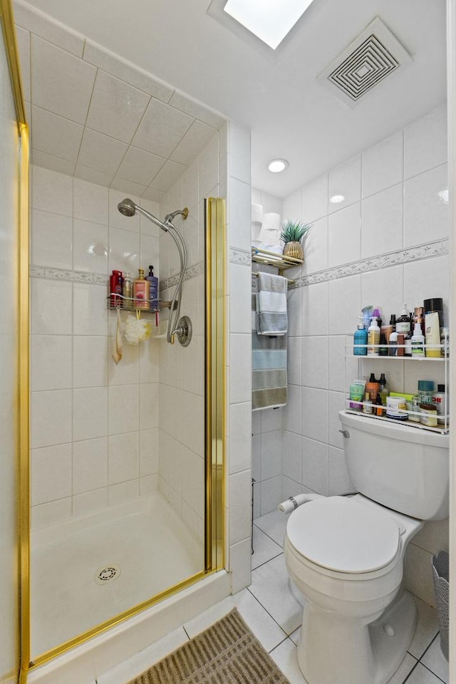 11212 Cottonwood Dr Unit 23A, Palos Hills, IL 60465 - bathroom with tile patterned flooring, toilet, a shower stall, visible vents, and tile walls
