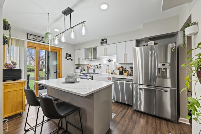 11212 Cottonwood Dr Unit 23A, Palos Hills, IL 60465 - kitchen featuring dark wood finished floors, wall chimney range hood, a center island, appliances with stainless steel finishes, and backsplash