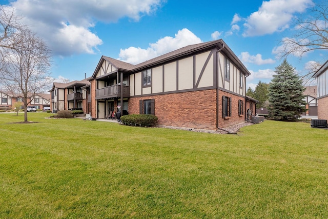11212 Cottonwood Dr Unit 23A, Palos Hills, IL 60465 - view of home's exterior with stucco siding, a lawn, brick siding, a balcony, and central AC unit