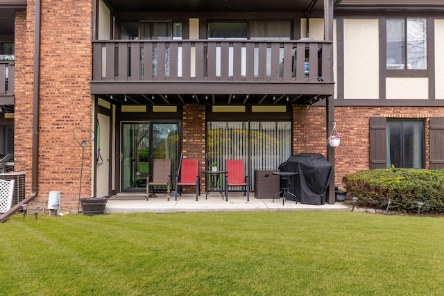 11212 Cottonwood Dr Unit 23A, Palos Hills, IL 60465 - rear view of house featuring a patio, a balcony, stucco siding, brick siding, and a lawn