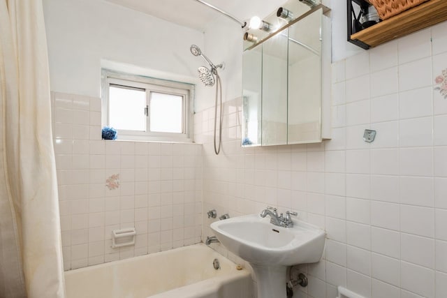 bathroom with shower / bath combo with shower curtain and tile walls