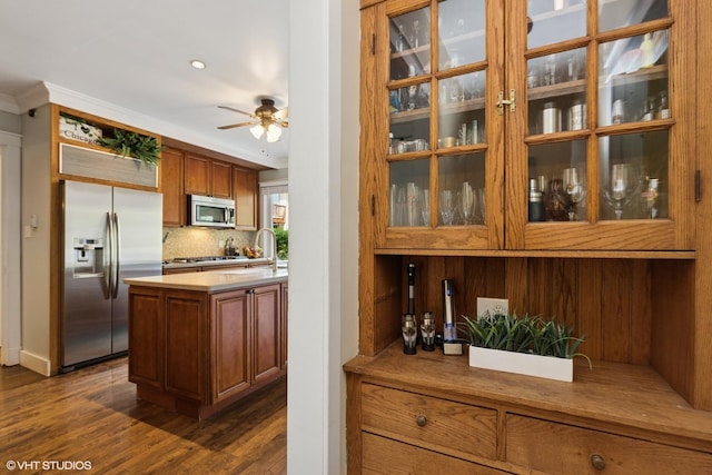 1046 N Hainesville Rd, Round Lake Beach, IL 60073 - bar featuring stainless steel appliances, ceiling fan, dark wood-style floors, decorative backsplash, and ornamental molding