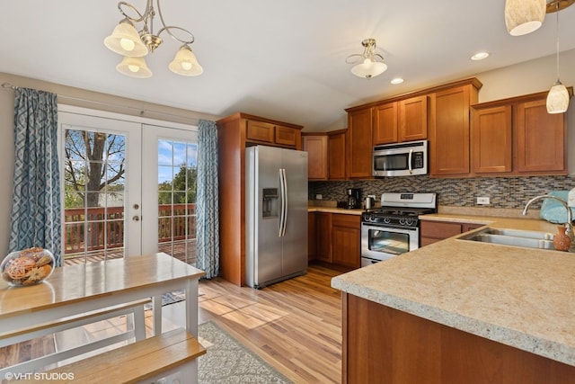 1046 N Hainesville Rd, Round Lake Beach, IL 60073 - kitchen with appliances with stainless steel finishes, brown cabinets, light countertops, a sink, and light wood finished floors