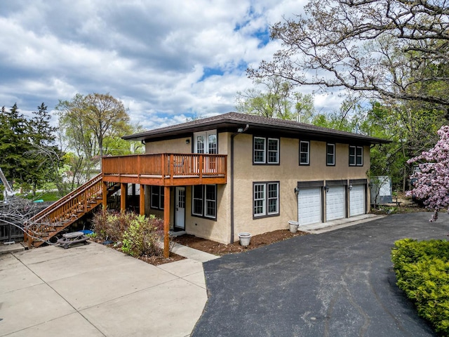 1046 N Hainesville Rd, Round Lake Beach, IL 60073 - view of front of property featuring stucco siding, asphalt driveway, stairs, a garage, and a deck