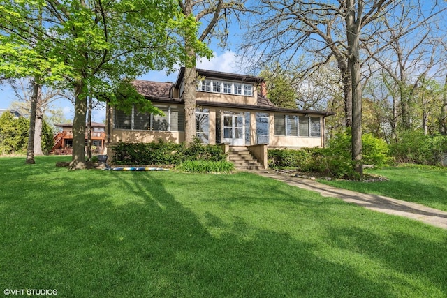 1046 N Hainesville Rd, Round Lake Beach, IL 60073 - view of front facade with a sunroom, stairs, and a front lawn