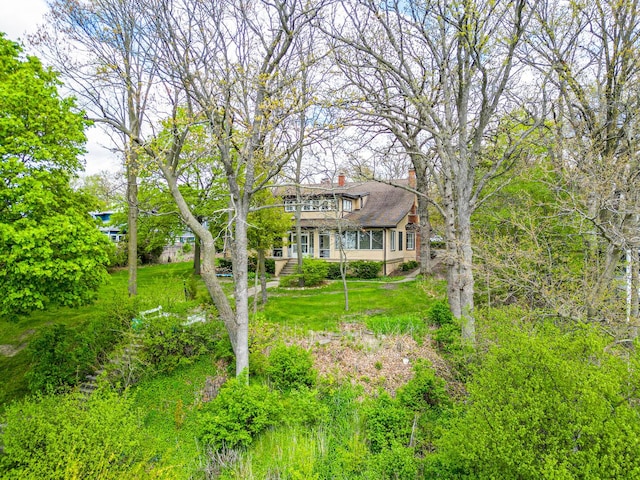1046 N Hainesville Rd, Round Lake Beach, IL 60073 - view of front of property featuring a chimney, a front lawn, and a balcony