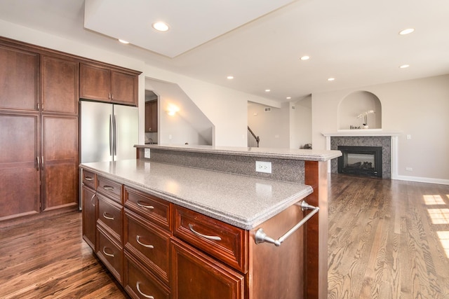 6433 Davidson Ct, Gurnee, IL 60031 - kitchen with dark wood finished floors, stainless steel fridge, a glass covered fireplace, a kitchen island, and recessed lighting
