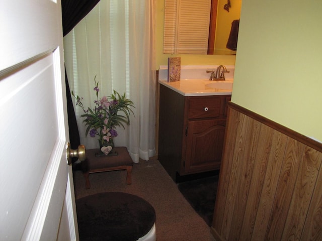 full bathroom with wooden walls, vanity, and a wainscoted wall