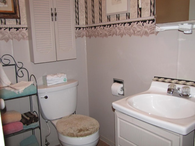 half bathroom with vanity and toilet