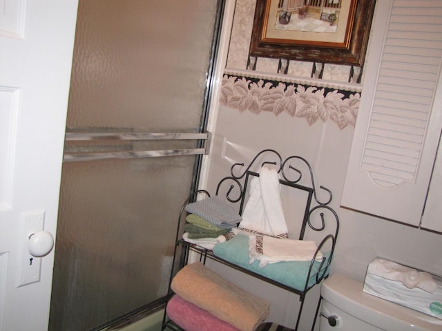 bathroom with an enclosed shower and toilet