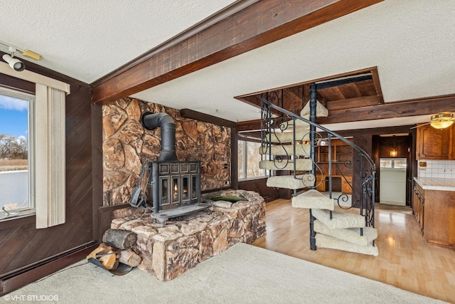 42136 N 7th Ave, Antioch, IL 60002 - living area with a wood stove, stairway, wood finished floors, a textured ceiling, and wood walls