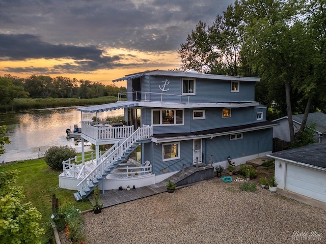 42136 N 7th Ave, Antioch, IL 60002 - back of property at dusk featuring a garage, stairway, a deck with water view, and a balcony