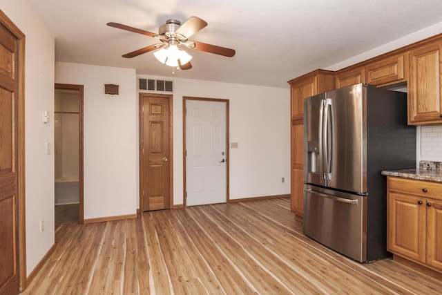 kitchen with a ceiling fan, brown cabinets, light wood-style flooring, stainless steel refrigerator with ice dispenser, and visible vents