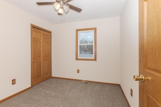 unfurnished bedroom featuring ceiling fan, baseboards, and carpet