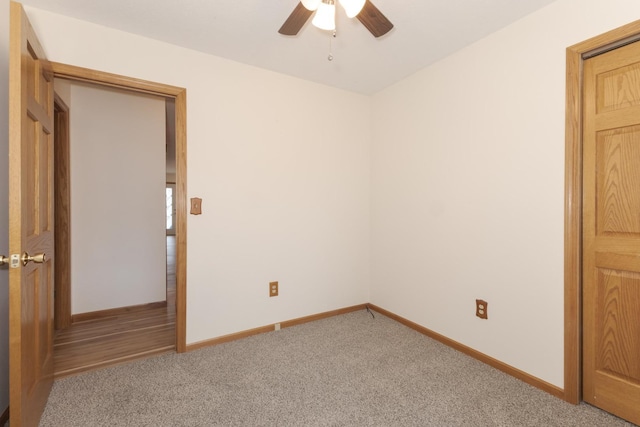 unfurnished room with baseboards, a ceiling fan, and light colored carpet