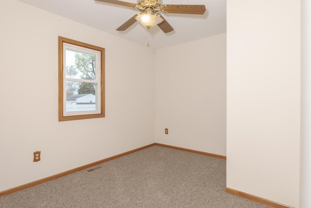 spare room featuring ceiling fan, visible vents, baseboards, and light carpet