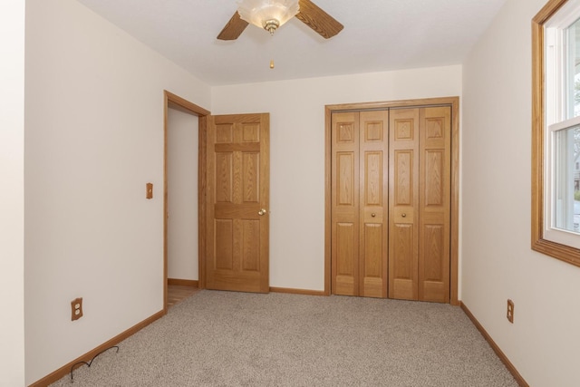 unfurnished bedroom with ceiling fan, baseboards, a closet, and light colored carpet