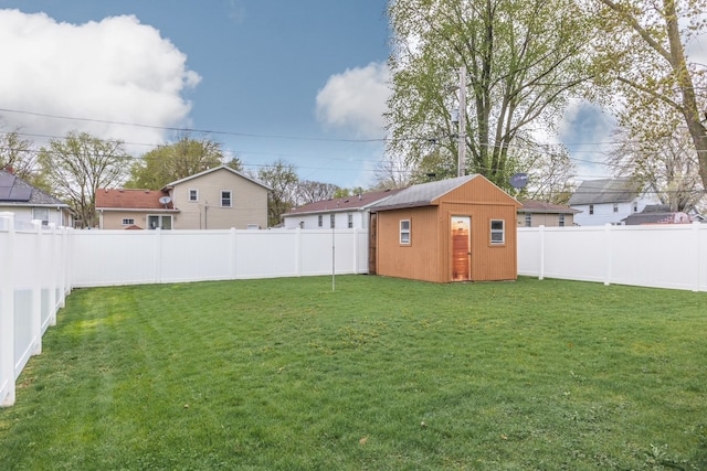 view of yard with an outdoor structure, a shed, and a fenced backyard