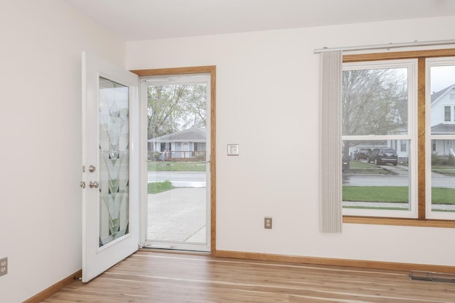 entryway with wood finished floors, visible vents, and baseboards