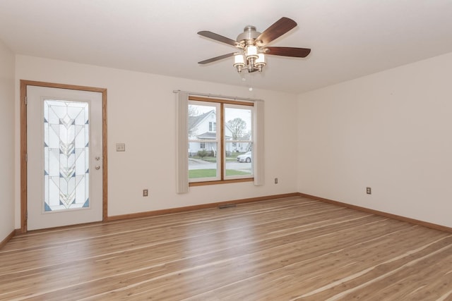 unfurnished room with baseboards, a ceiling fan, and light wood finished floors