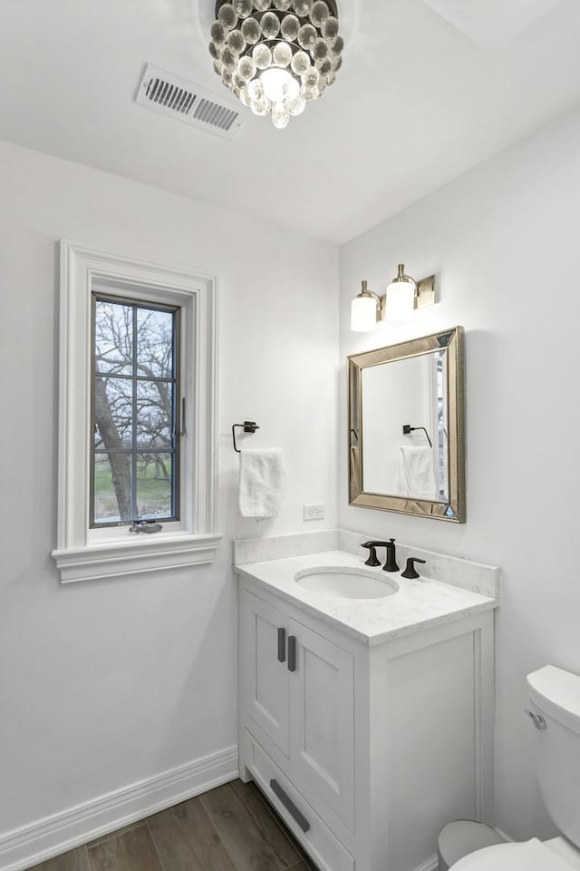 41W050 Stoneridge Ln, Elgin, IL 60124 - half bathroom featuring toilet, baseboards, visible vents, vanity, and wood finished floors
