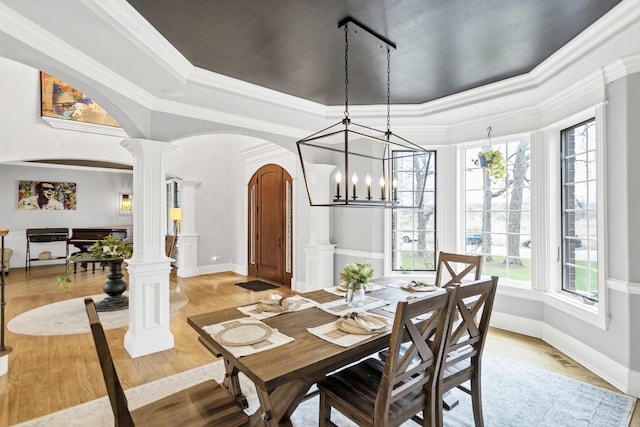 41W050 Stoneridge Ln, Elgin, IL 60124 - dining area featuring a notable chandelier, light wood-style flooring, baseboards, arched walkways, and ornate columns