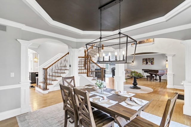 41W050 Stoneridge Ln, Elgin, IL 60124 - dining room with a tray ceiling, decorative columns, stairs, wood finished floors, and arched walkways