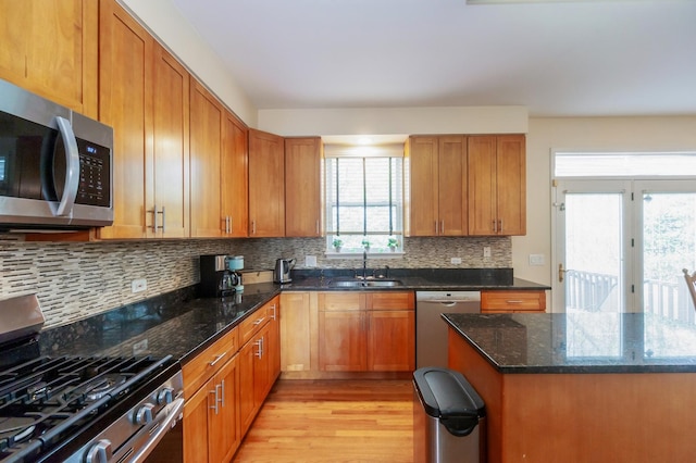 716 Samson Way, Northbrook, IL 60062 - kitchen with appliances with stainless steel finishes, a sink, light wood finished floors, dark stone counters, and decorative backsplash