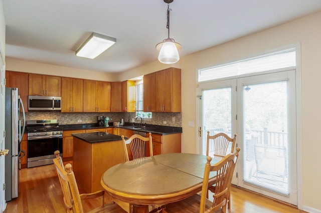 716 Samson Way, Northbrook, IL 60062 - kitchen featuring appliances with stainless steel finishes, decorative backsplash, brown cabinetry, and light wood-style flooring