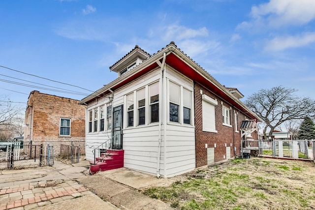 7658 S Laflin St, Chicago, IL 60620 - view of side of property with cooling unit, entry steps, a gate, fence, and brick siding