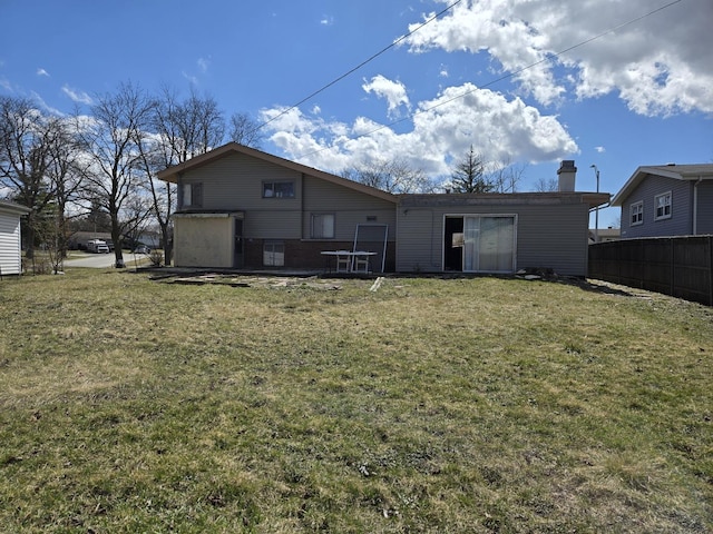 back of property featuring a chimney and a lawn