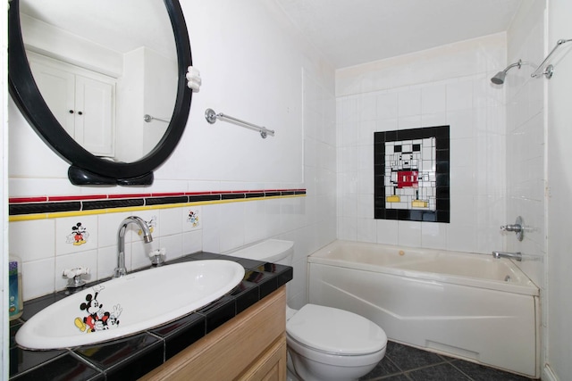 full bath with vanity, tile walls, shower / bath combination, toilet, and tile patterned flooring