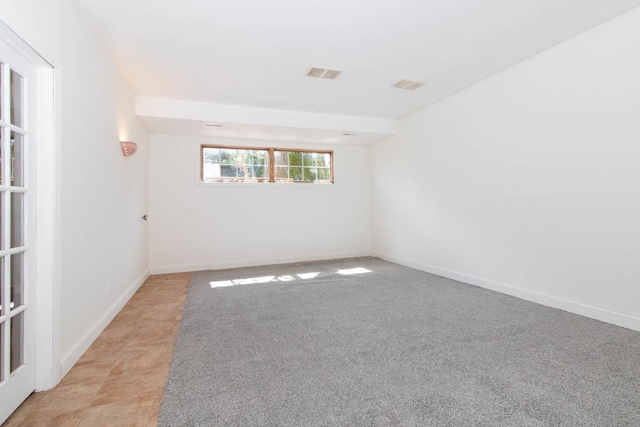 unfurnished room featuring baseboards and visible vents