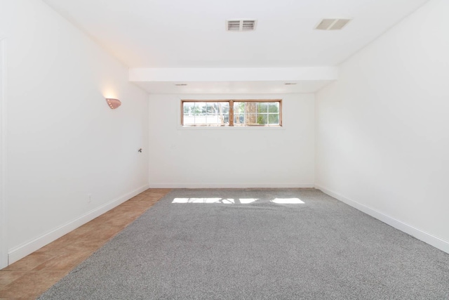 carpeted spare room with baseboards and visible vents