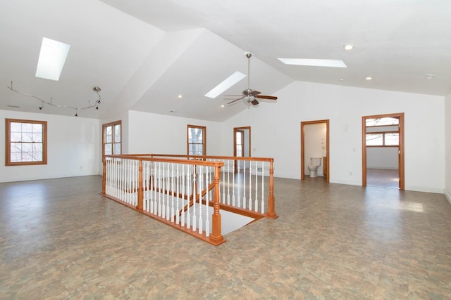 spare room with a skylight, a wealth of natural light, ceiling fan, and high vaulted ceiling