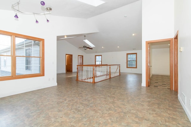 unfurnished room featuring high vaulted ceiling, baseboards, a ceiling fan, and a skylight