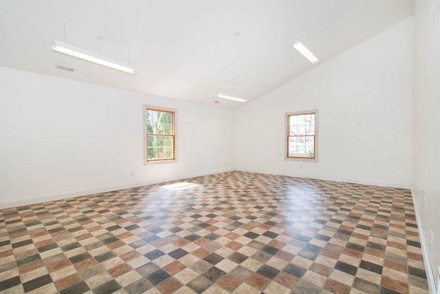unfurnished room featuring high vaulted ceiling, a wealth of natural light, visible vents, and baseboards